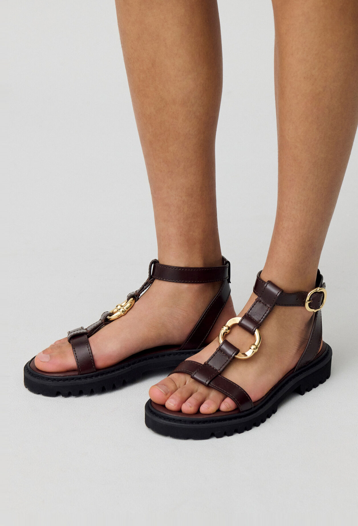 Sandalias de cuero con aro dorado.